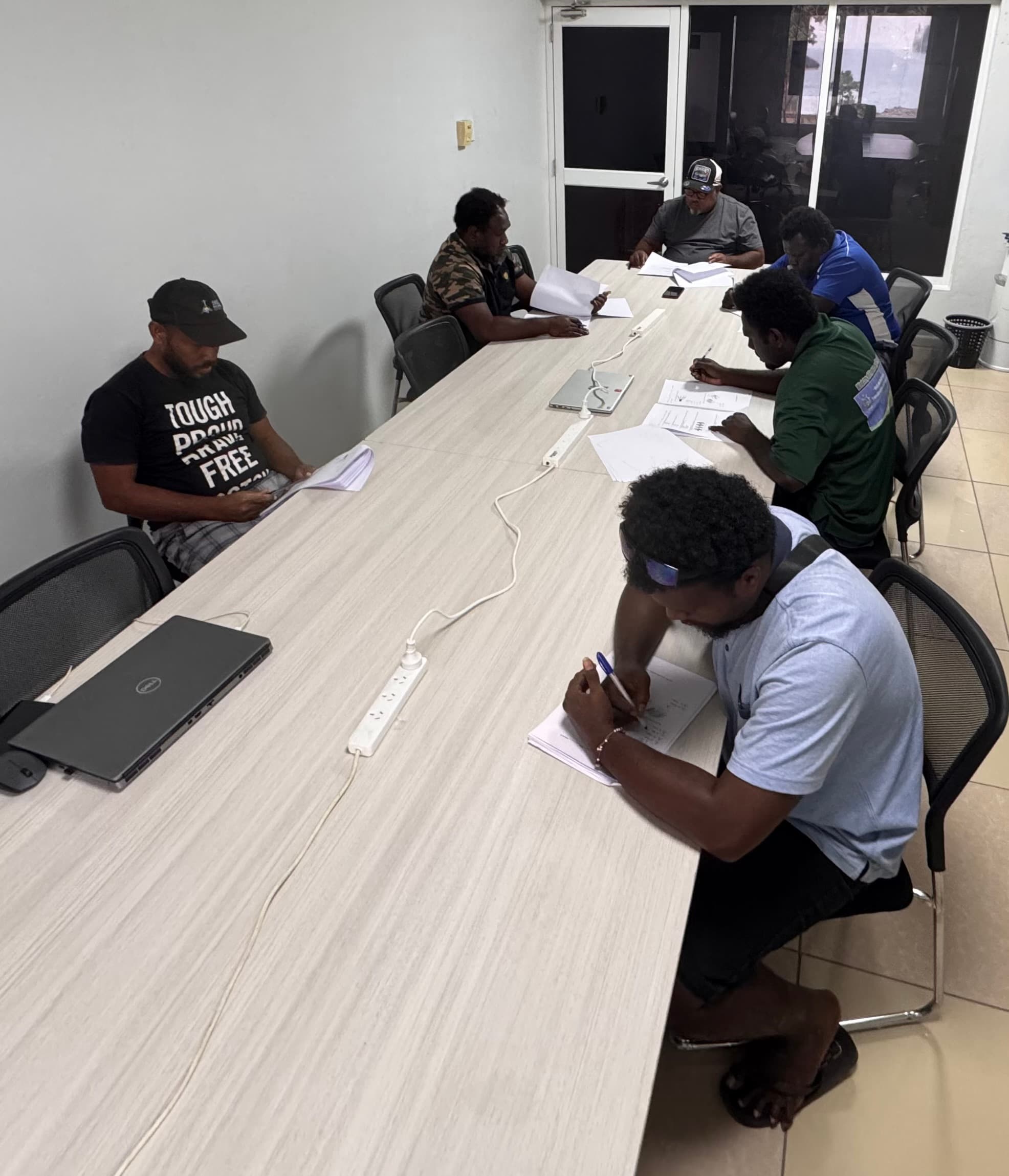 Participants completing written assessment papers for a certification pathway